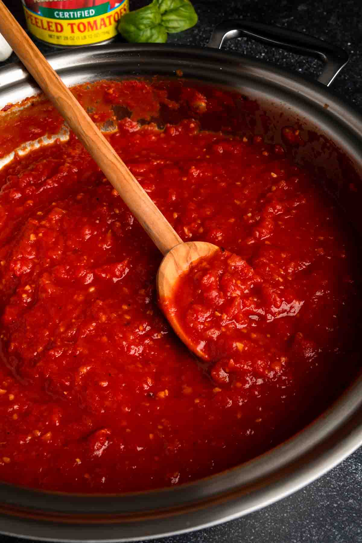 A wooden spoon in a pan of San Marzano tomato marinara sauce. 