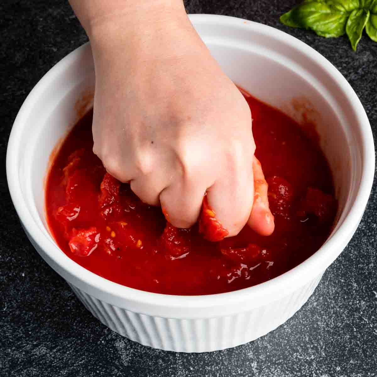 Crushing San Marzano tomatoes by hand.