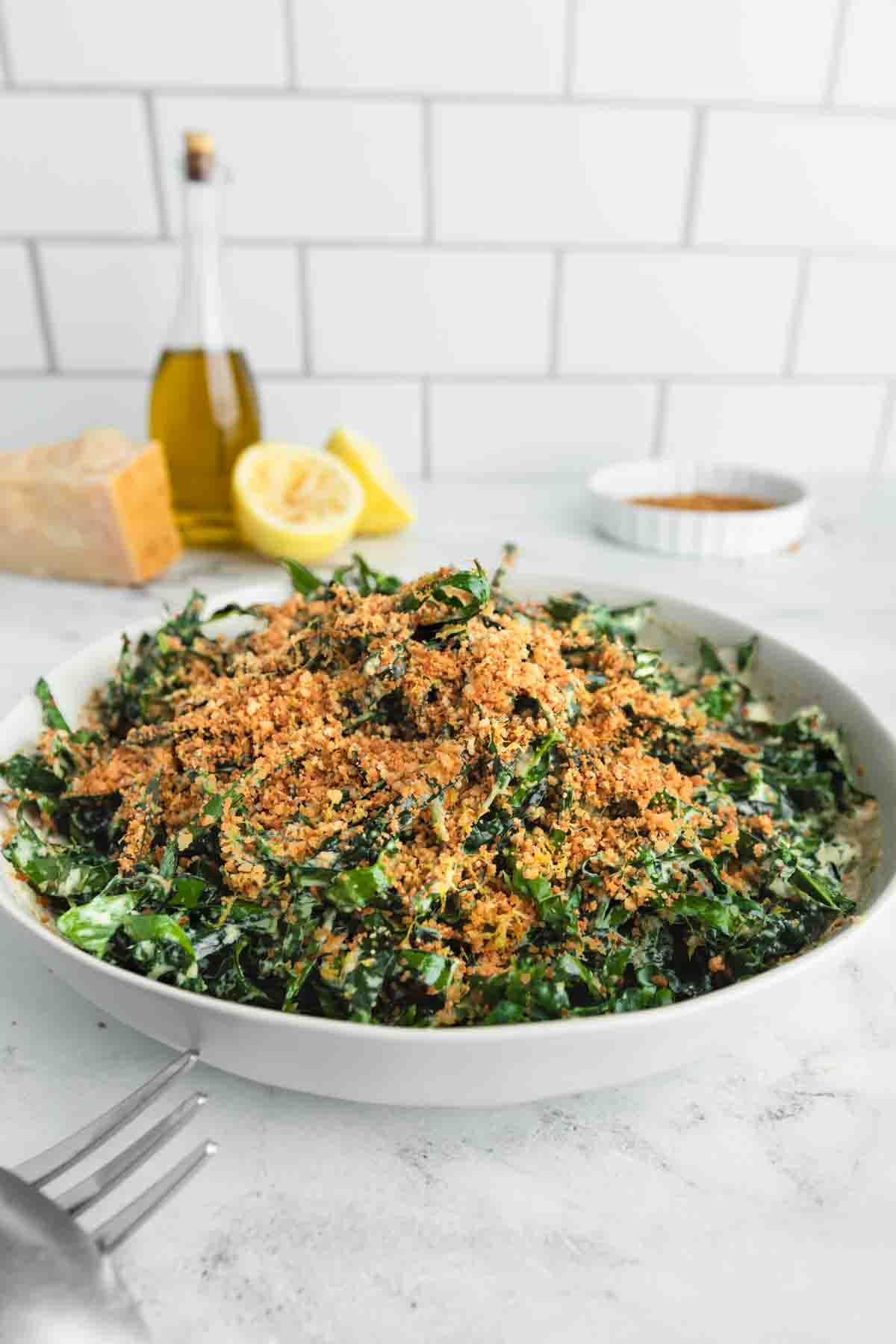 A bowl of Tuscan kale salad with lemon breadcrumbs and tahini Parmesan dressing.