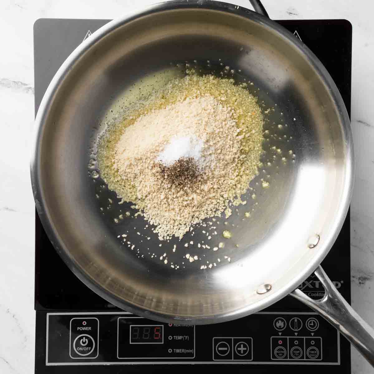Olive oil, panic breadcrumbs, salt and pepper in a frying pan.