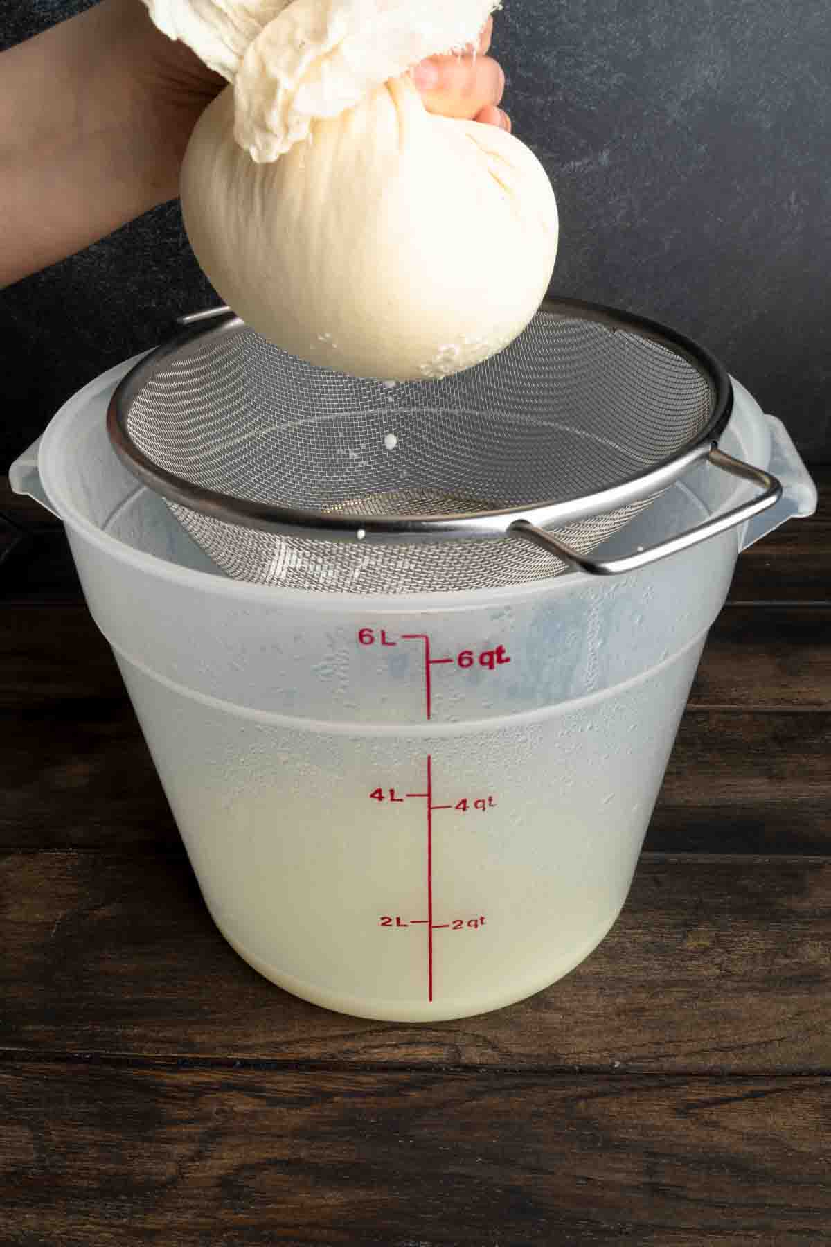 Squeezing the last bits of whey from a ball of fresh ricotta cheese.