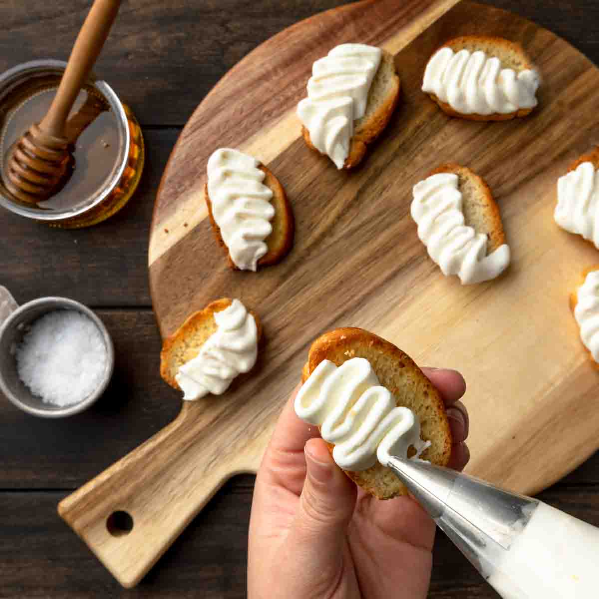 Piping ribbons of whipped ricotta onto crostini with a petal decorating tip. 