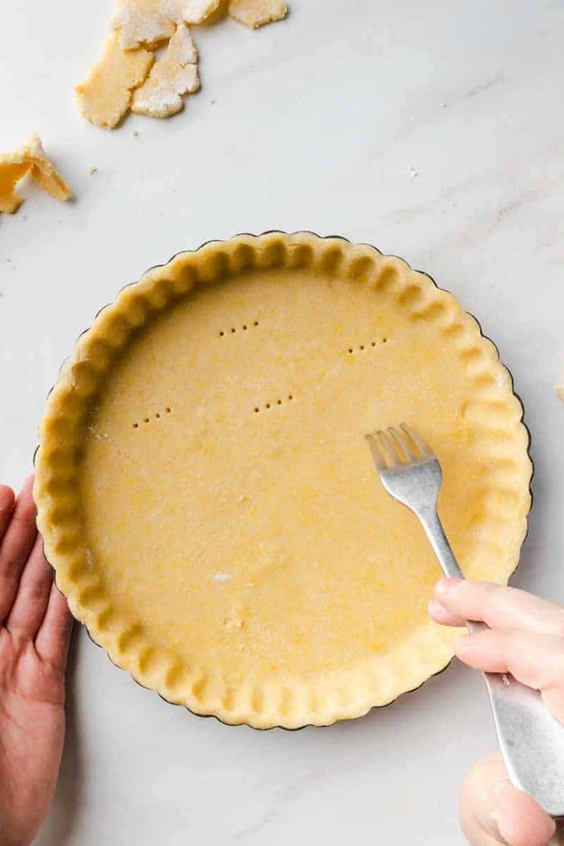 Docking the pie dough with a fork.