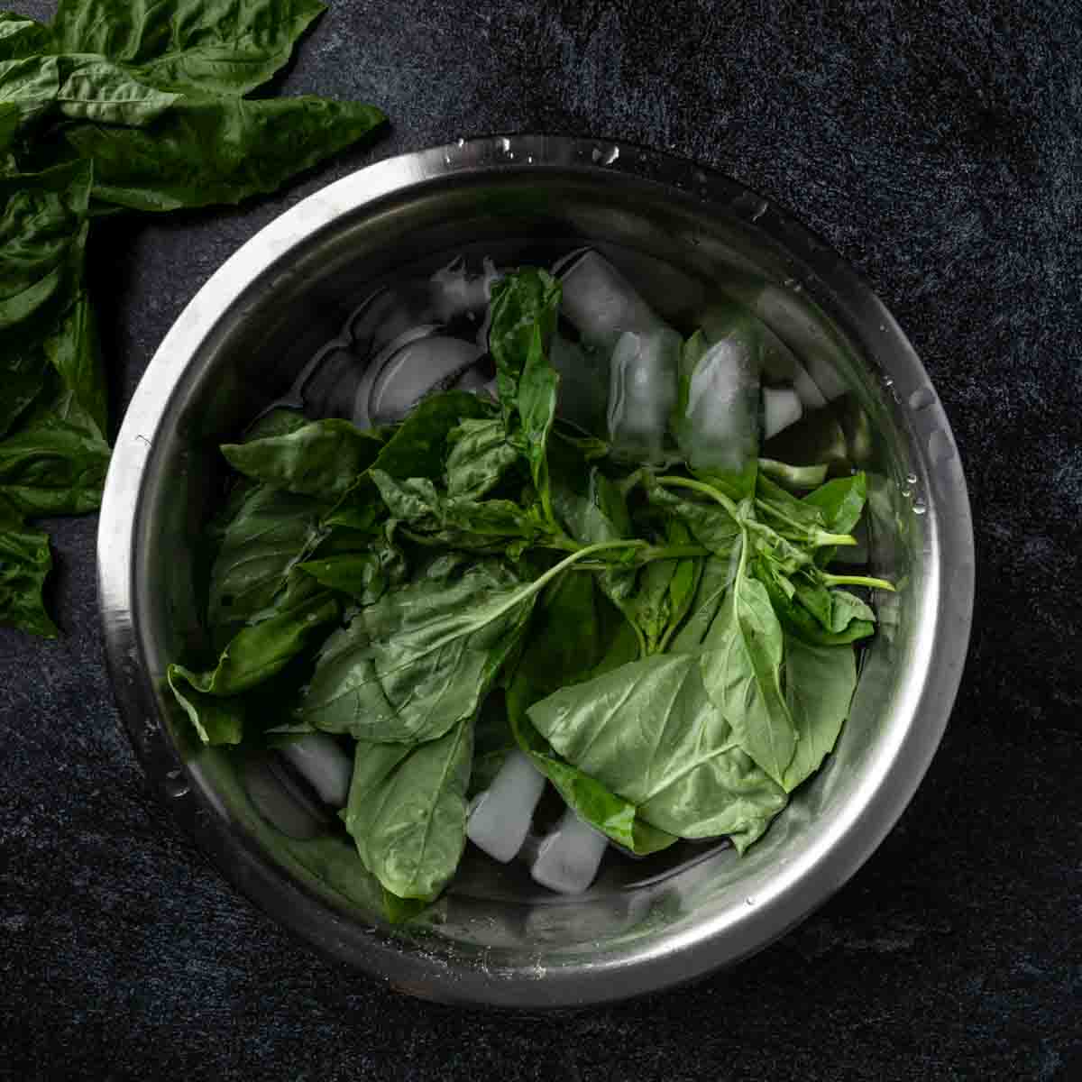 A bunch of basil crisping in an Ince water bath.