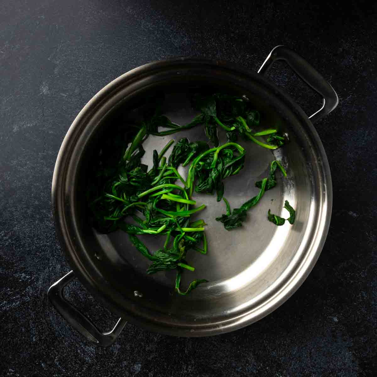 Fresh spinach, wilted in a pan.