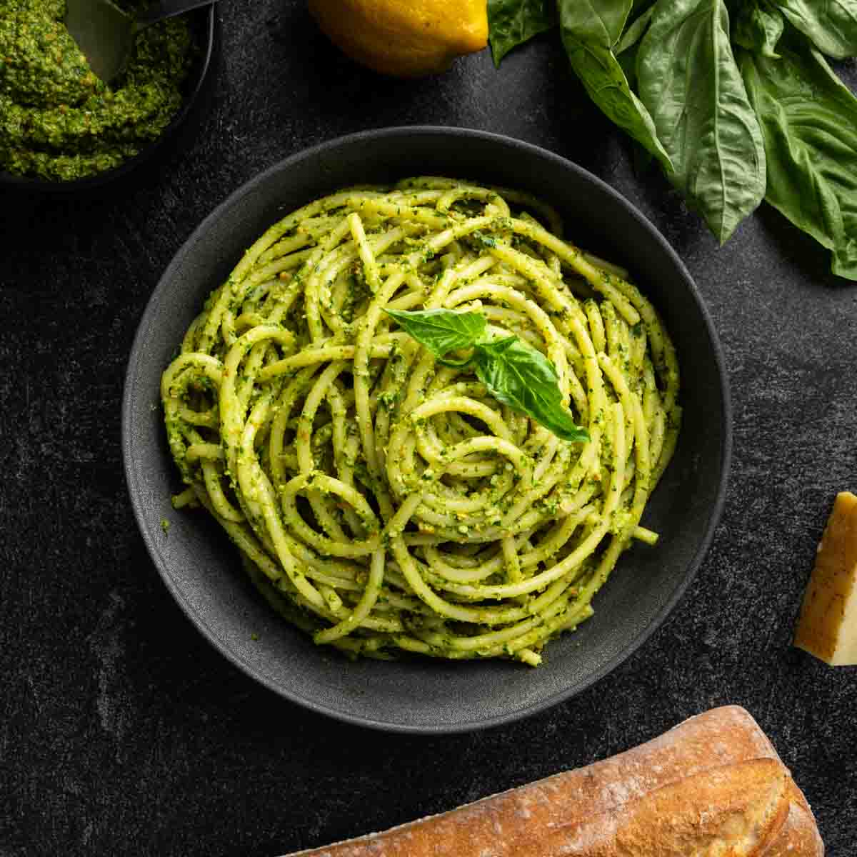 A big bowl of spaghetti and pesto with a homemade spinach pistachio pesto sauce.