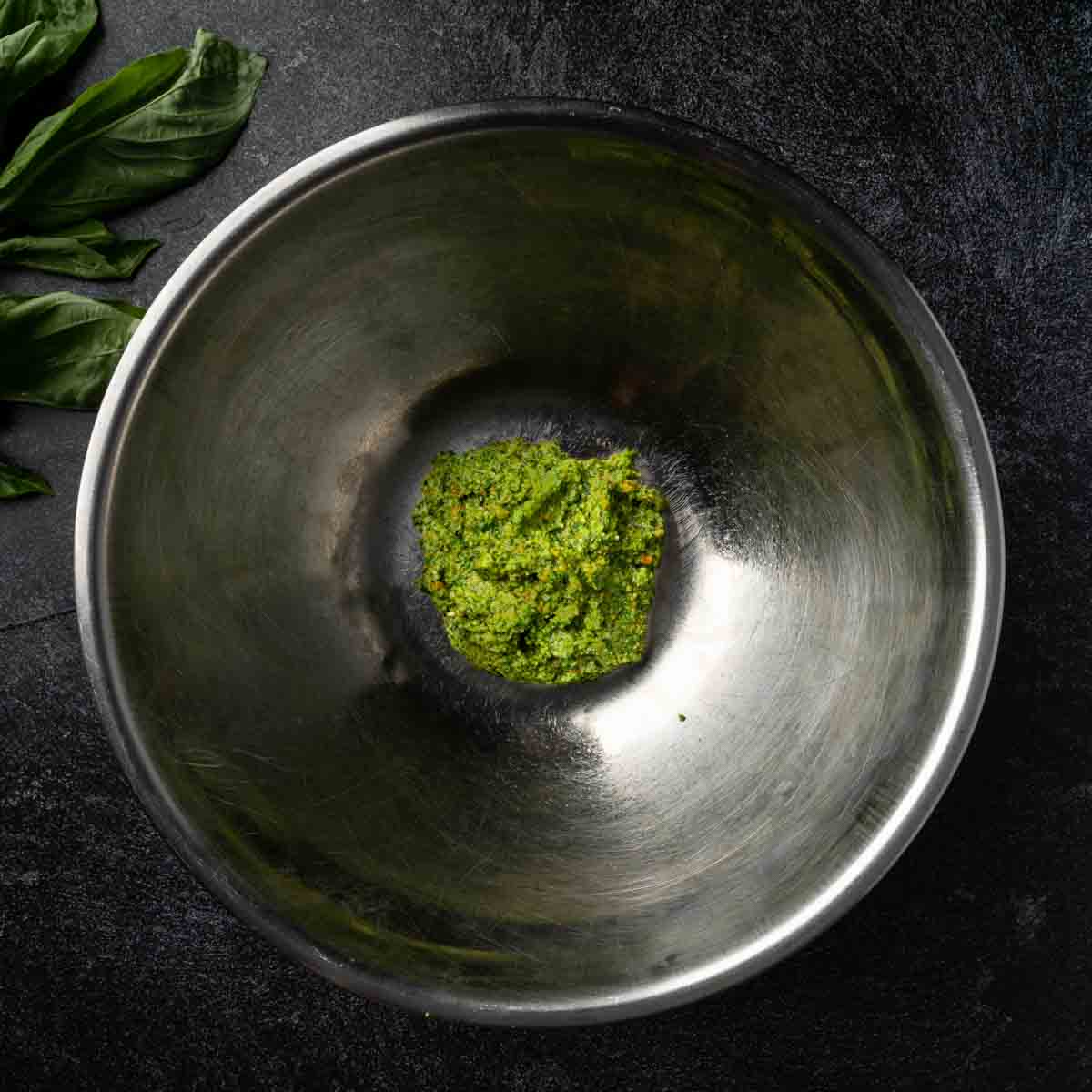 A large mixing bowl with a portion of homemade pesto sauce.