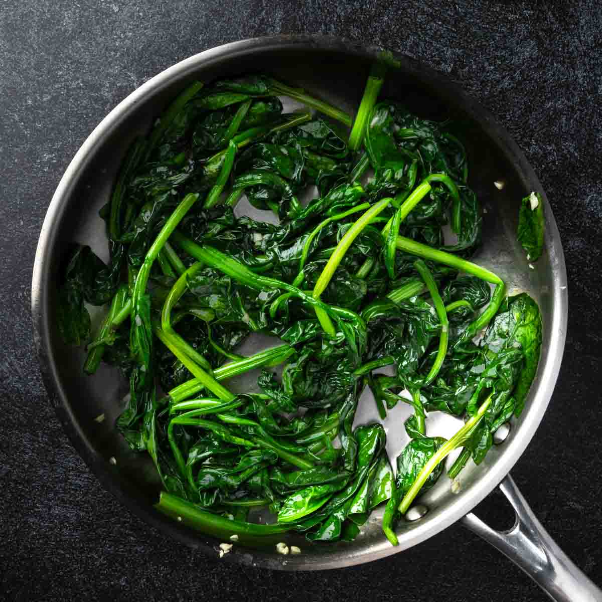 Sautéed spinach and garlic in a frying pan.