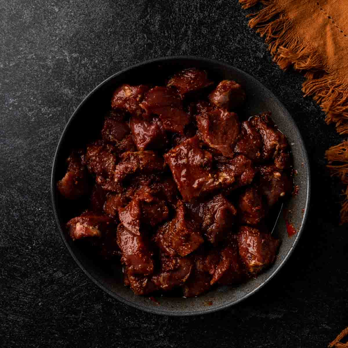 Baharat spiced lamb marinating in a bowl. 