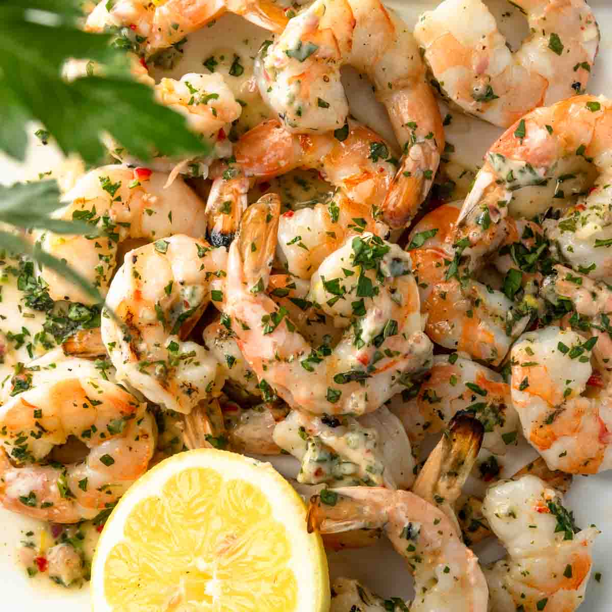 A big pile of chimichurri shrimp with fresh herbs. 