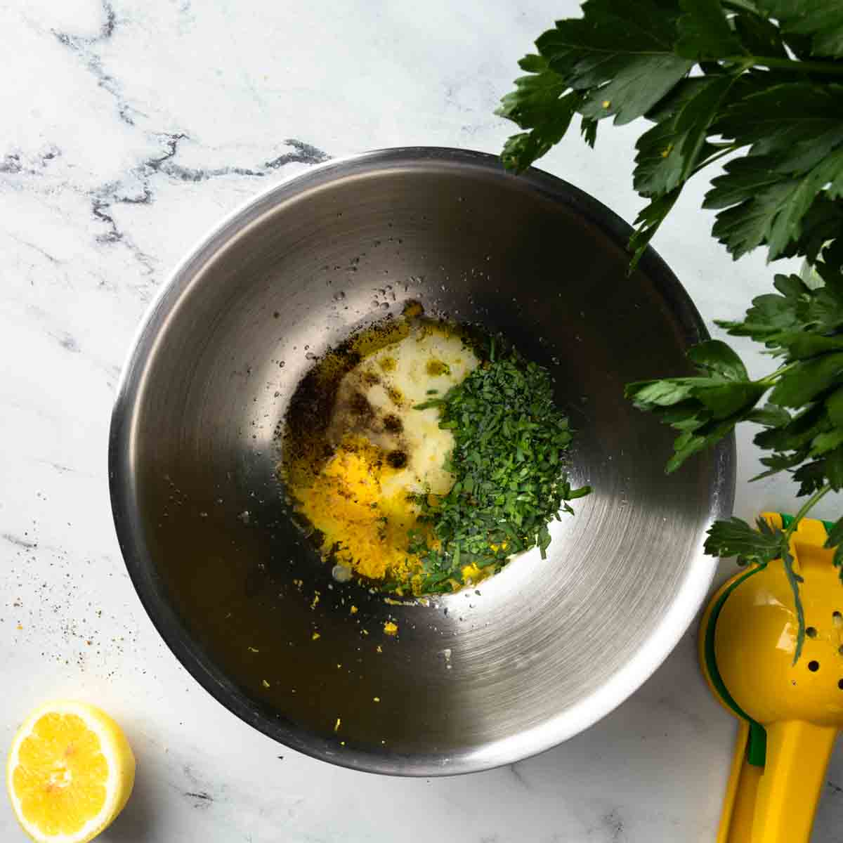 A bowl of parsley, lemon and olive oil. 