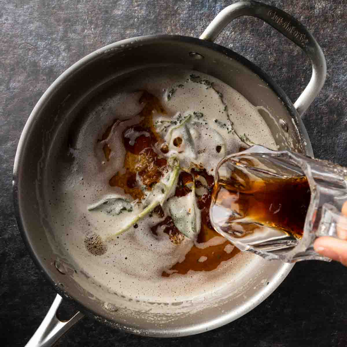 Adding balsamic vinegar to the pan of hot brown butter.