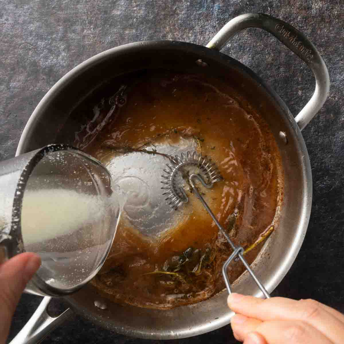 Whisking starchy pasta water into a pan of balsamic brown butter.