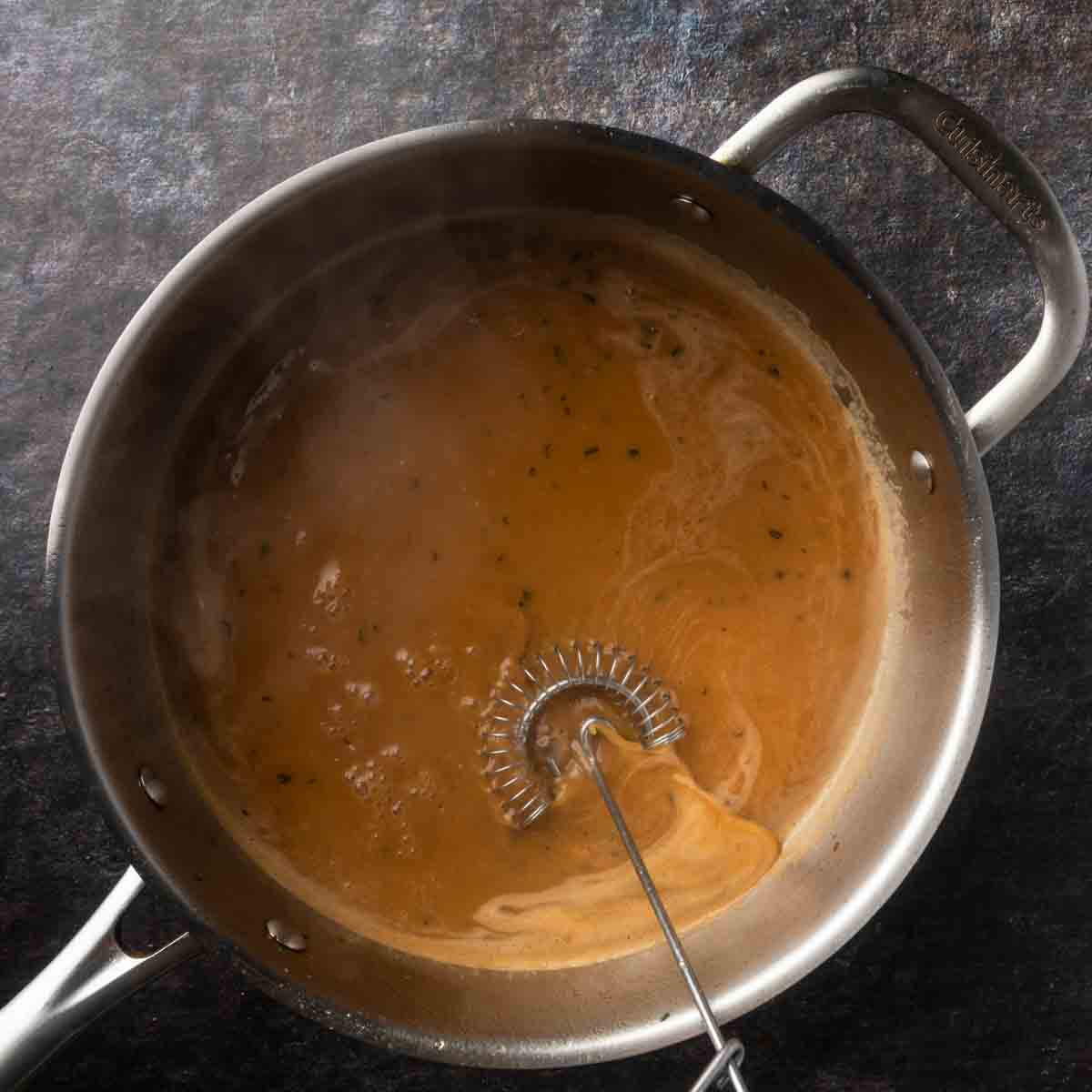 A smooth and thickened balsamic brown butter sauce simmering in a pan.
