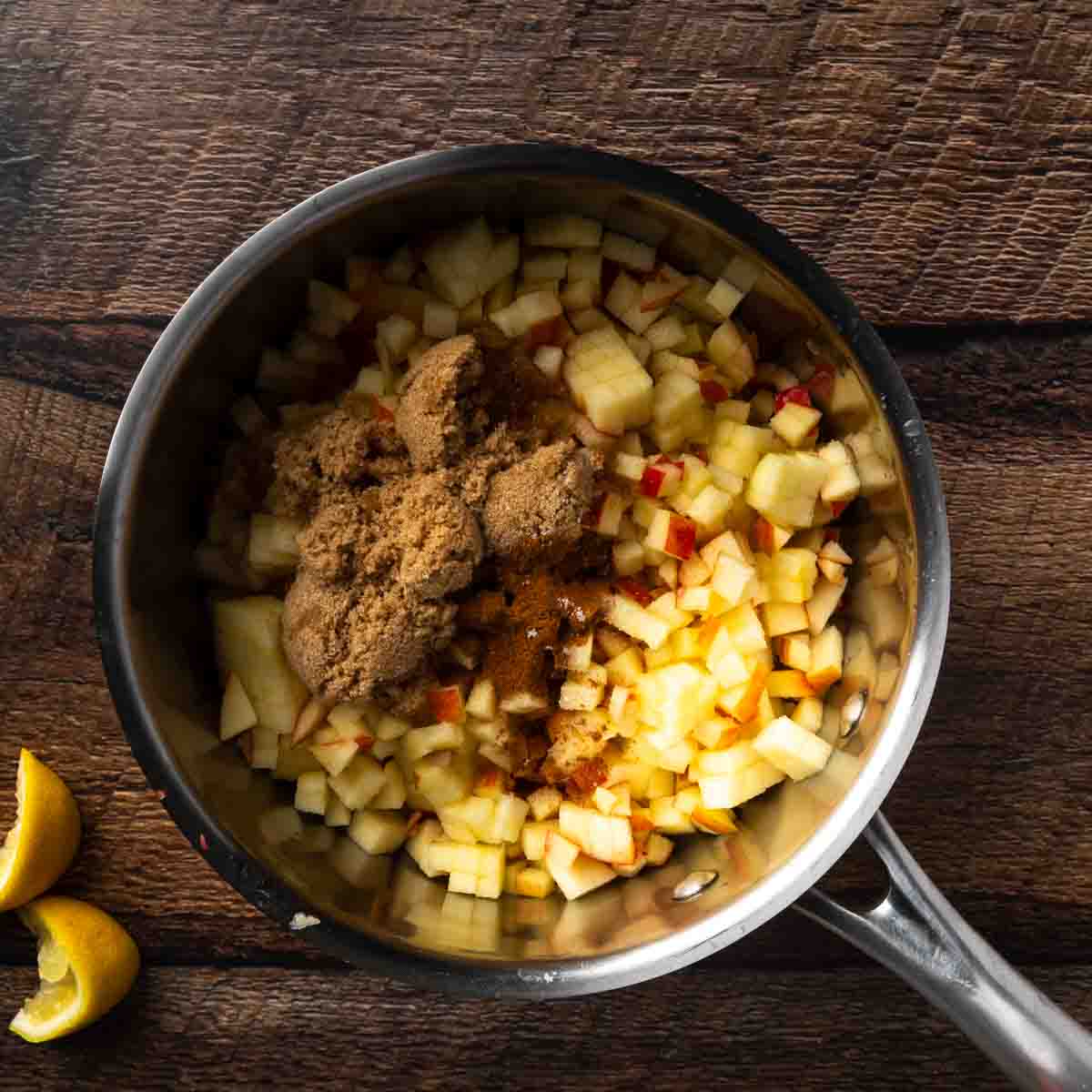 Diced apples with cinnamon and brown sugar in a pot. 