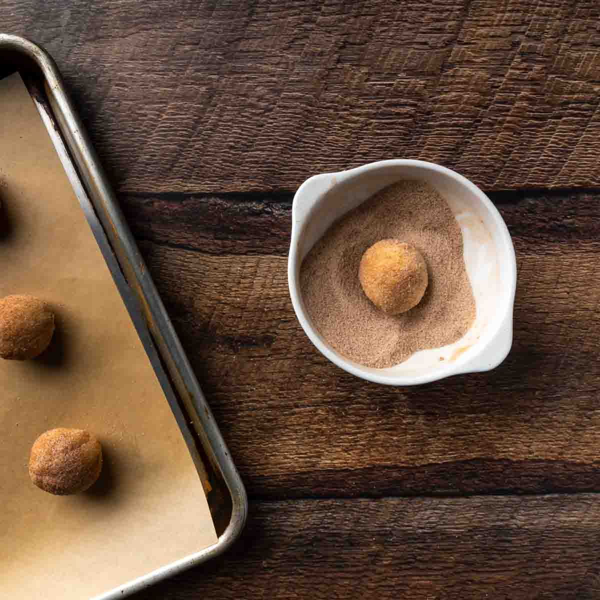 Rolling balls of cookie dough in cinnamon sugar. 