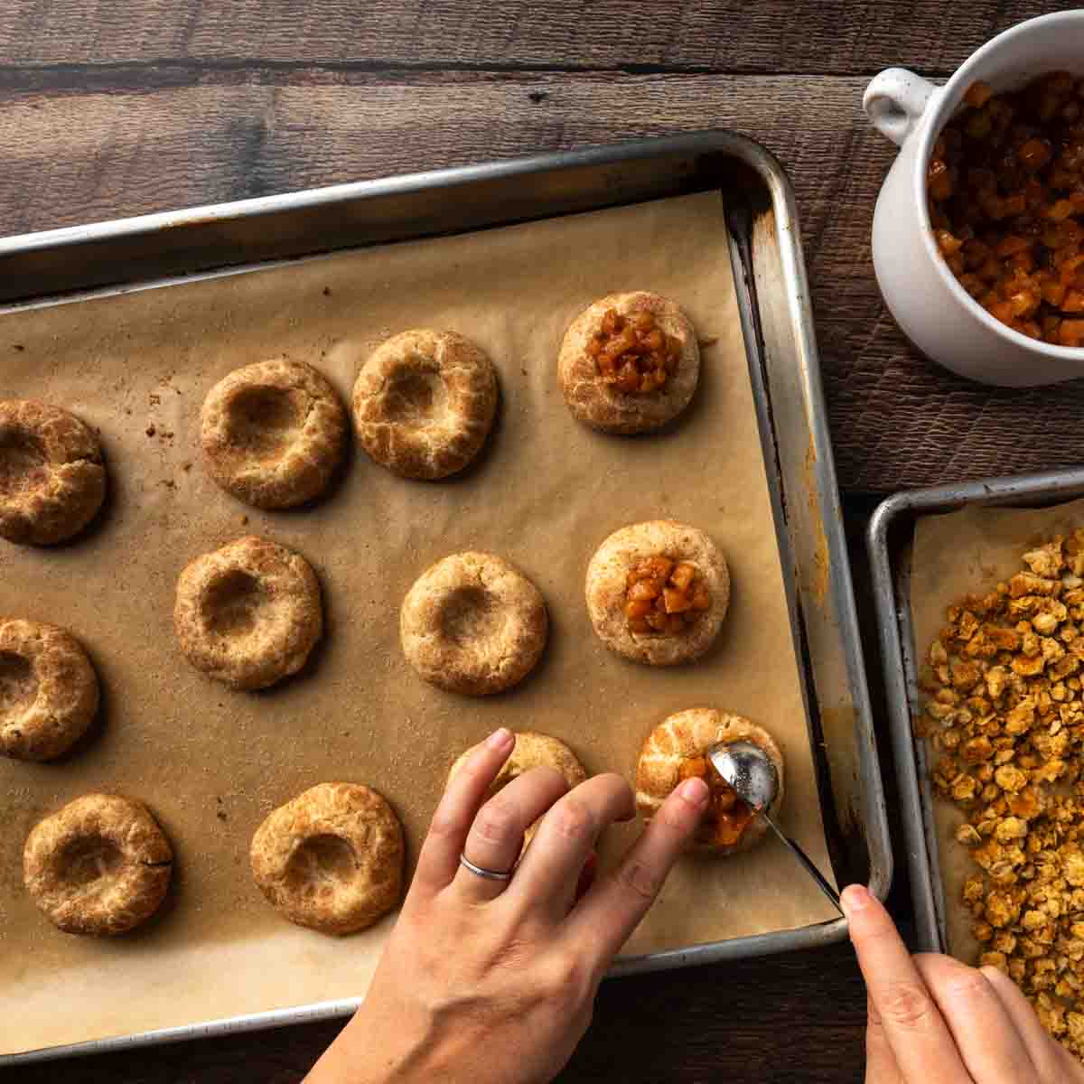 Filling the center of each cookie with a scoop of apple pie filling. 