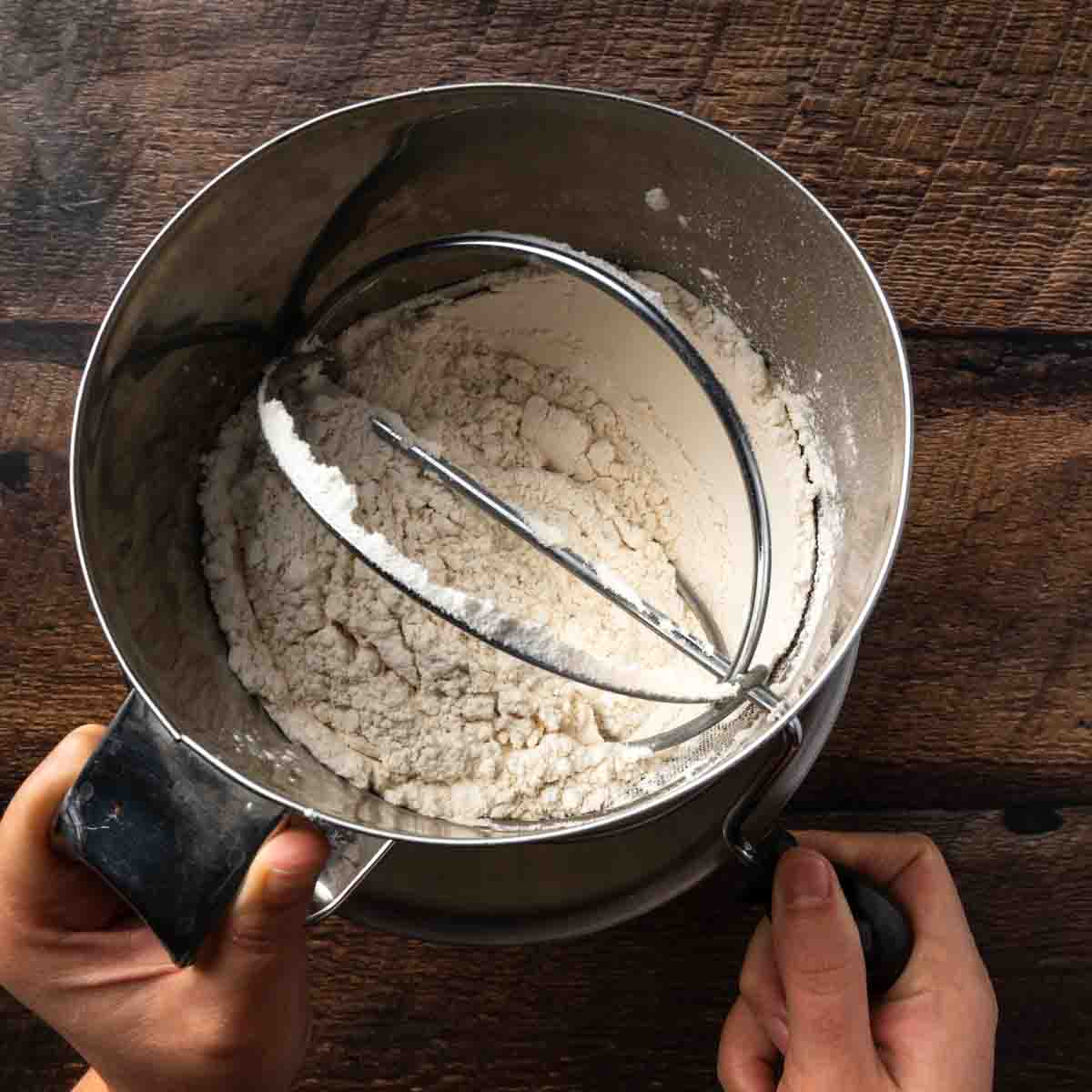 Sifting dry ingredients for cookie dough. 