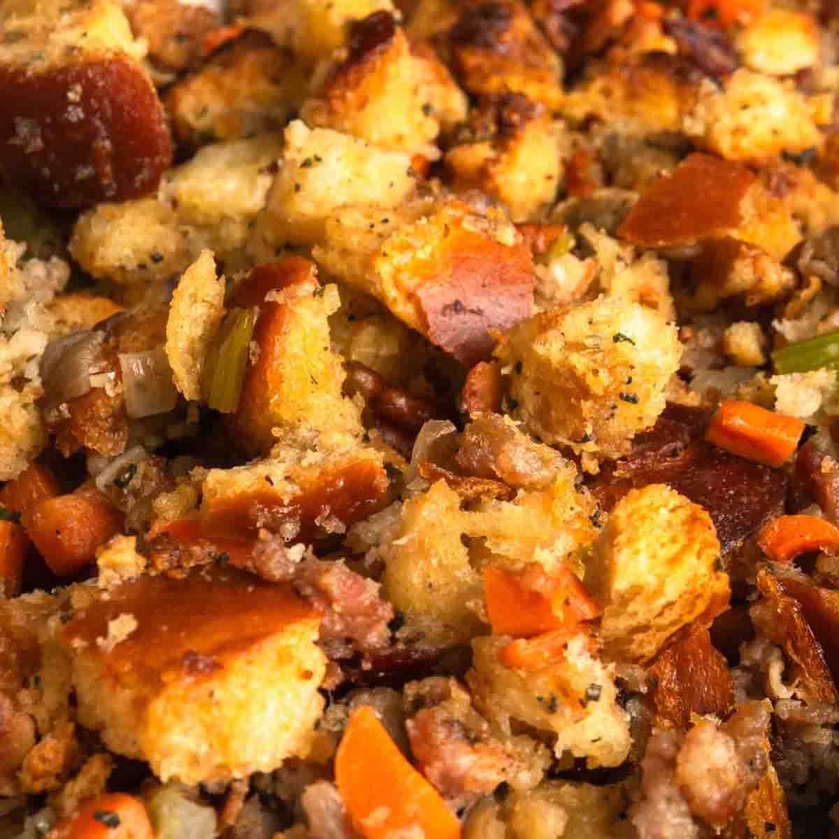 A close up image of challah stuffing with sausage, cranberries and pecans. 