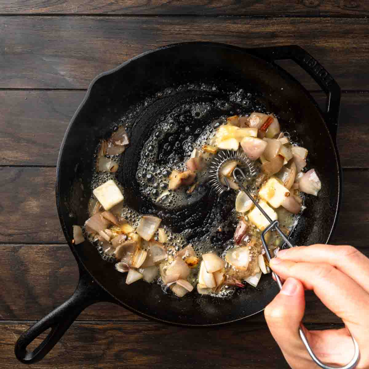 Sizzling butter being melted and whisked into the cast iron.