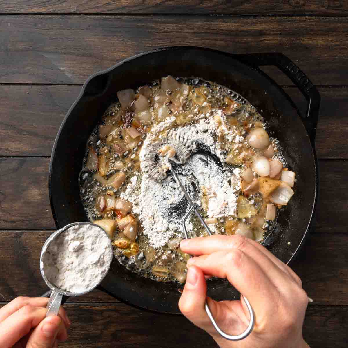 Stirring flour into the melted butter and shallots to make a roux.