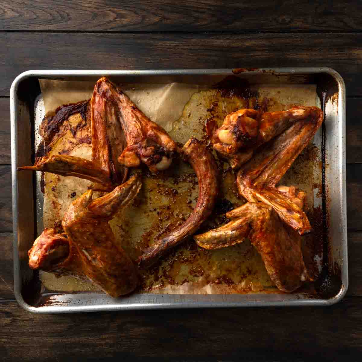 Golden roasted turkey wings on a baking sheet. 