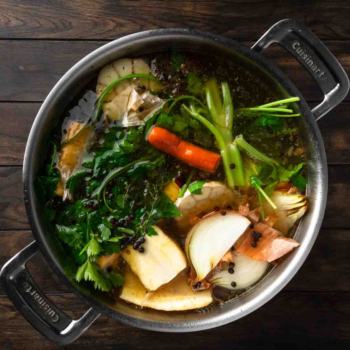 A big pot full of simmered turkey stock and fresh herbs and veggies. 