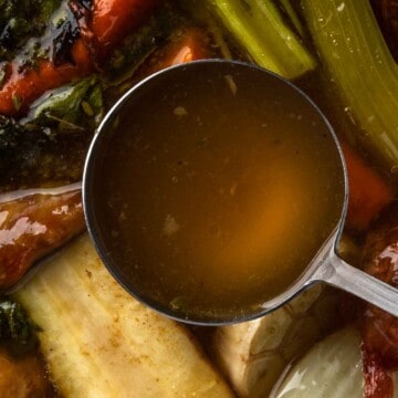 A close up ladle full of homemade turkey stock.