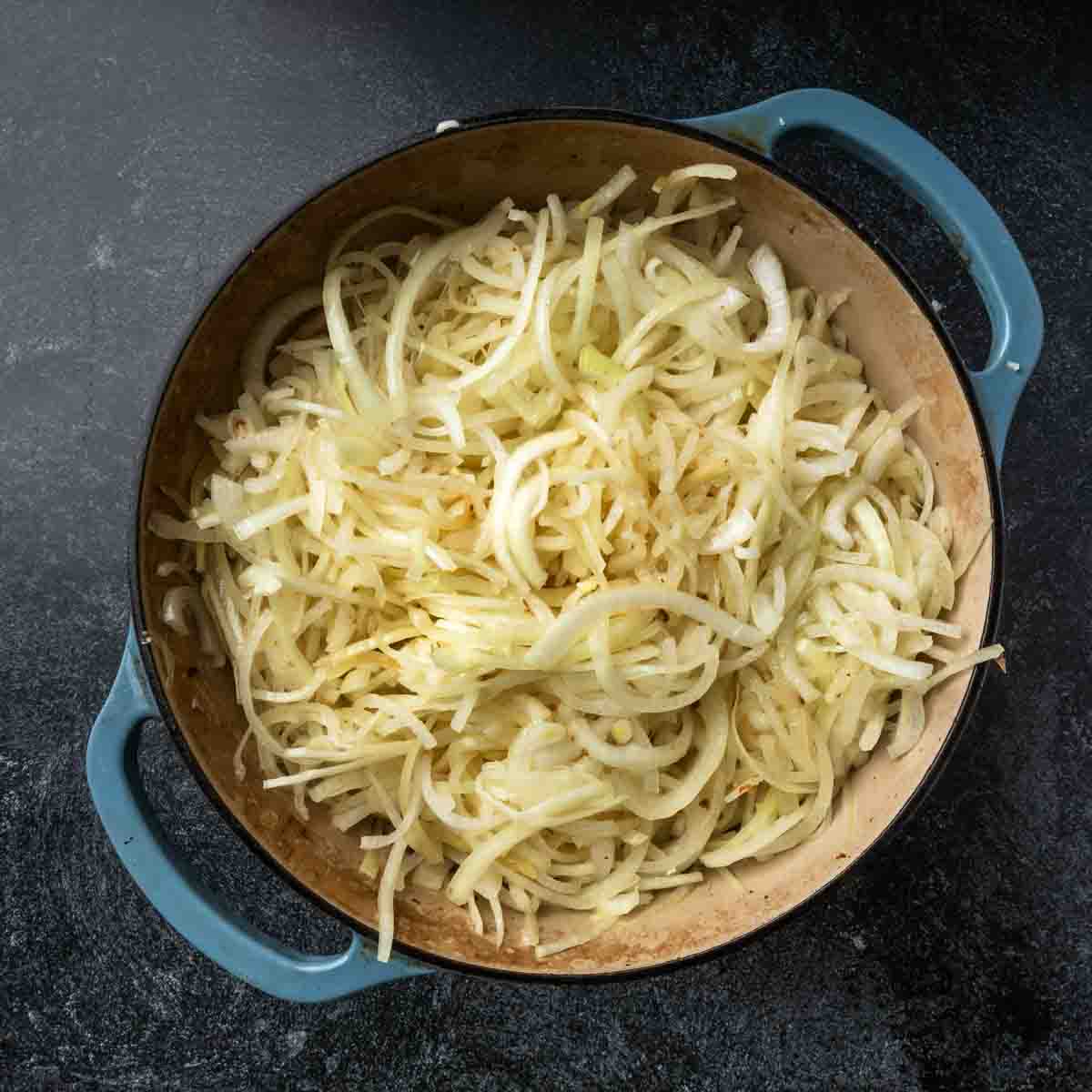 Onions and garlic beginning to wilt in a big Dutch oven pot. 