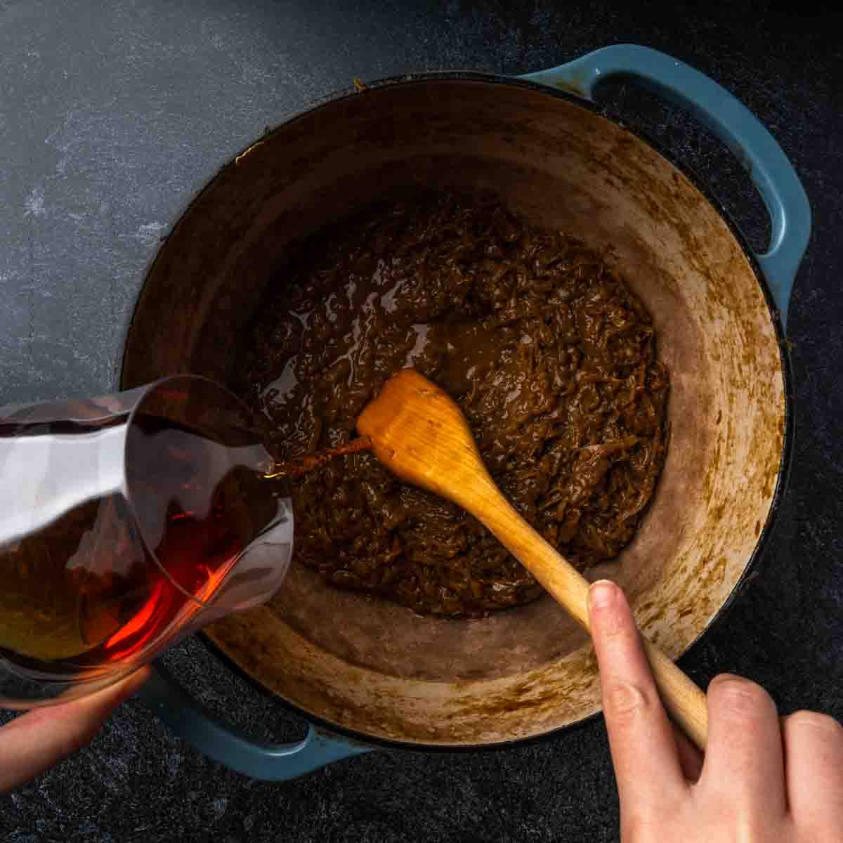 Deglazing a pot of caramelized onion with pour of brandy. 