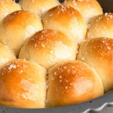 Mounds of maple butter glazed dinner rolls speckled with flaky salt.