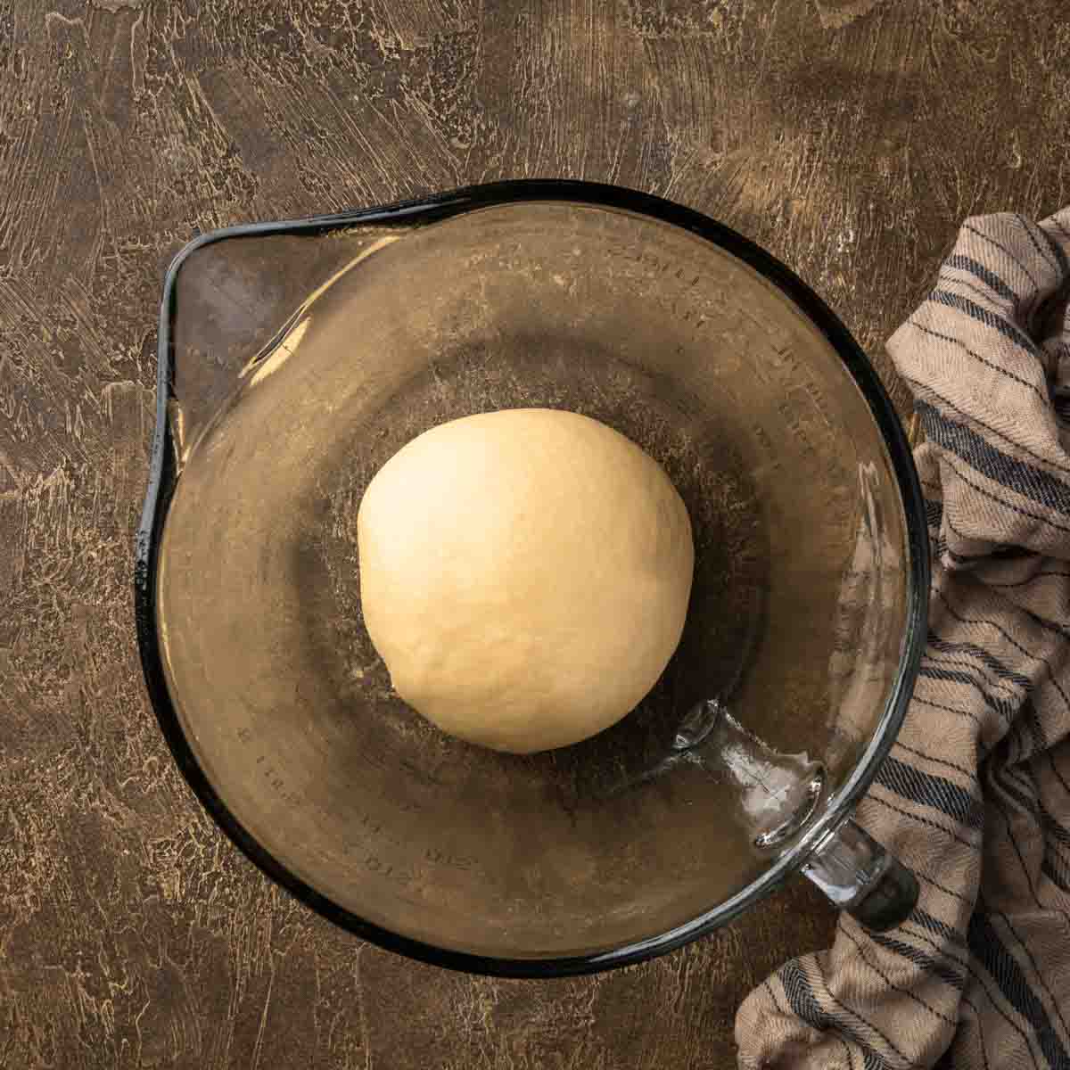 A small taught dough bowl in a greased mixing bowl.